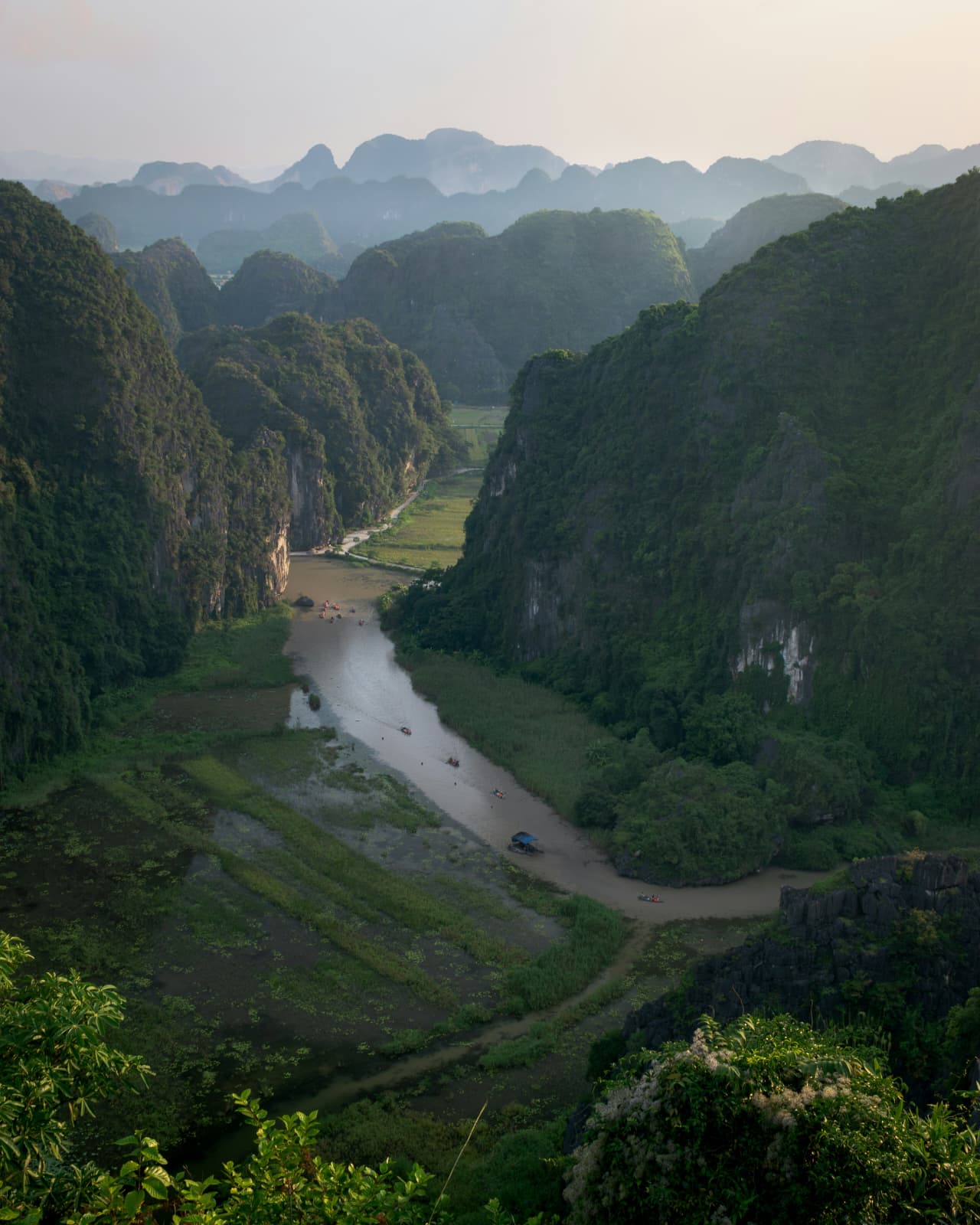 River winding through a green valley between karst mountains in Ninh Binh, seen from above